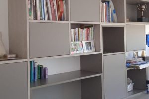 Librero de pared con nichos para libros y decoración. Incluye cajones y puertas push diseñado por California Closets